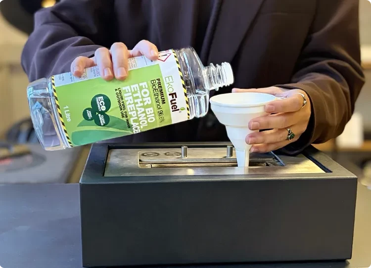 bio-ethanolbrandstof in een brander gieten met een plastic trechter